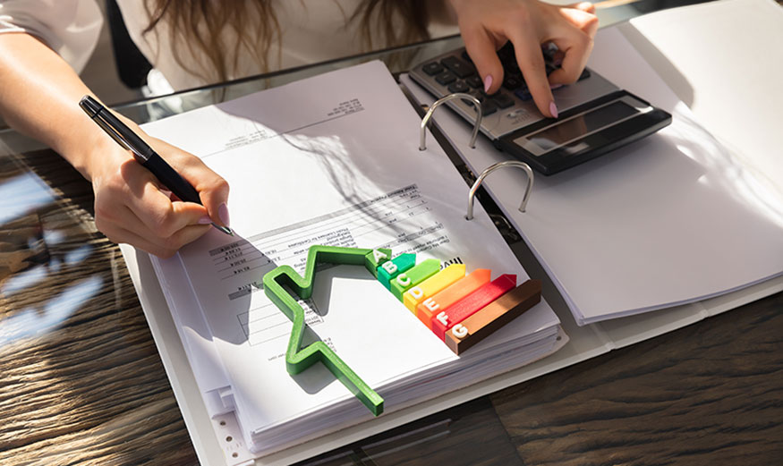 Femme faisant ses comptes avec une calculatrice et logo DPE posé devant elle.