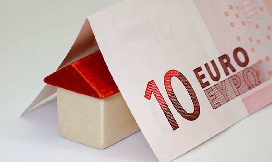 Figurine de maison sous un billet de 10€.