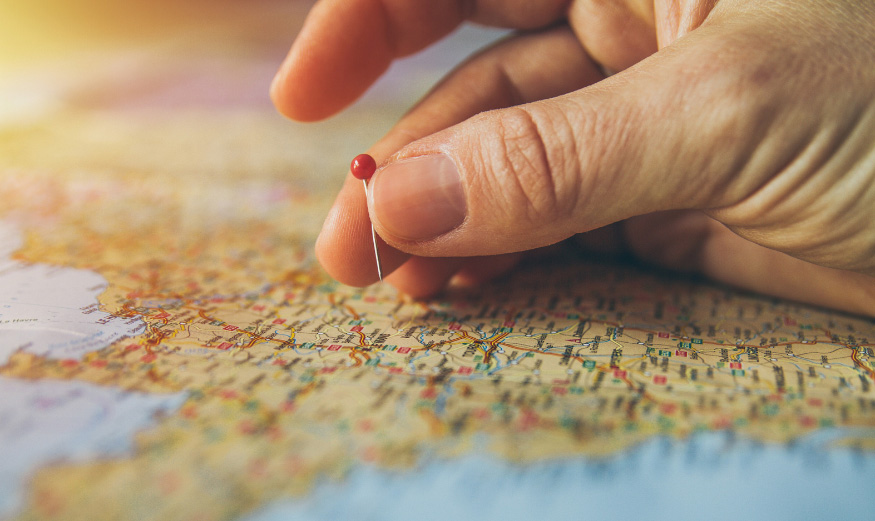 Une main qui choisit une ville sur une carte de France.