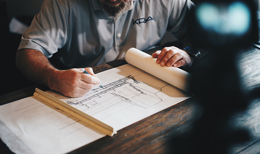 Homme dessinant un plan de maison.