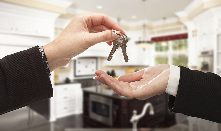 Une main donnant des clés à une autre main.