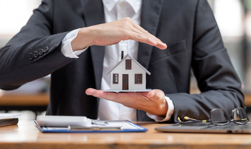 Personne tenant une maison signature, la protégeant au-dessus