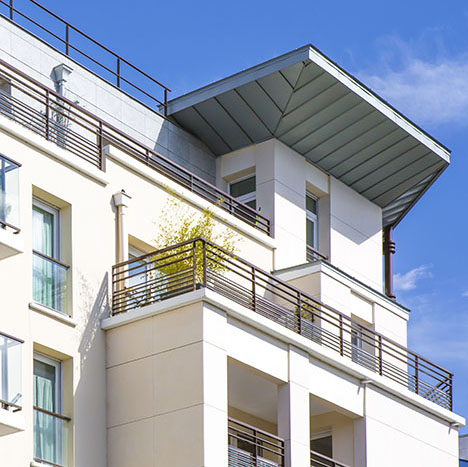 Façade blanche moderne d’un appartement neuf avec balcons