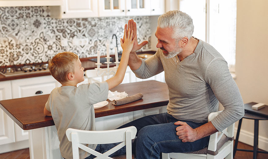 Grand-père qui tape dans la main de son petit-fils telle une victoire.
