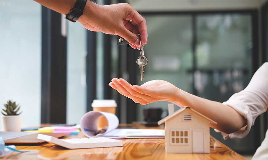 Un propriétaire donne les clefs d’un logement à une locataire.