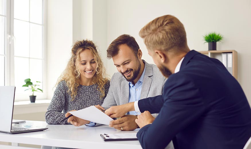 Conseiller immobilier avec un jeune couple souhaitant investir