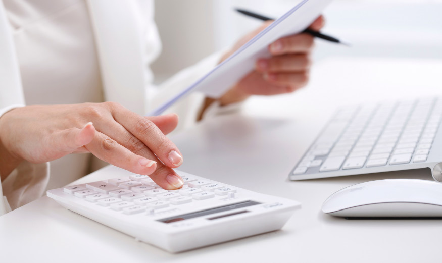 Main tapant sur une calculatrice.