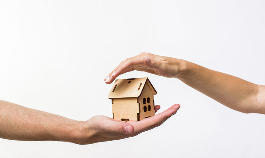 Maison protégée avec deux mains.