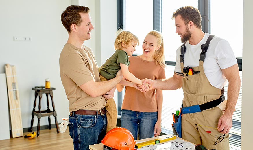constructeur qui serre la main à une famille 