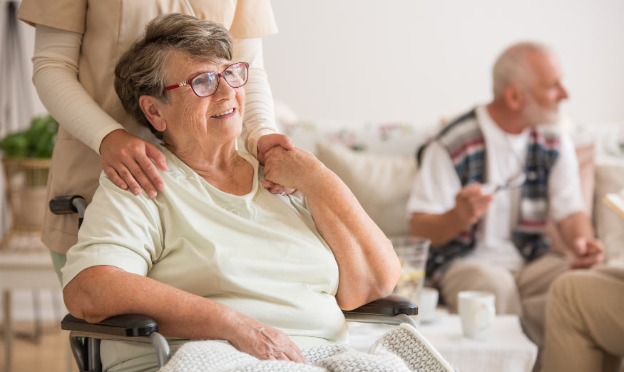 Femme âgée souriante, assise sur un fauteuil roulant