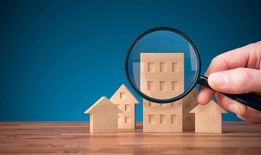 Loupe sur des maisons et des immeubles miniatures en bois