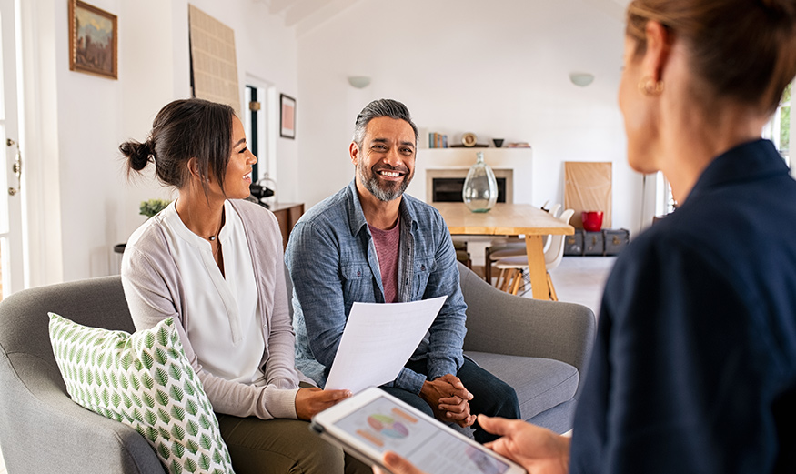Un couple discutant avec un conseiller immobilier.