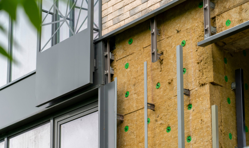 Isolation thermique de la façade d'un bâtiment à plusieurs étages avec de la laine minérale.